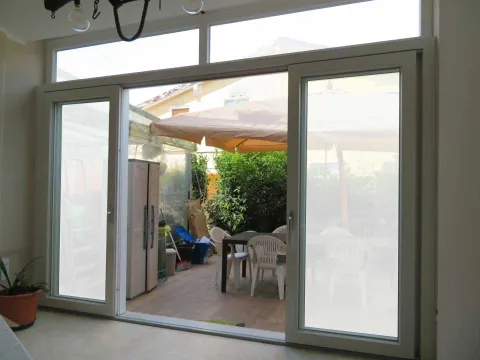 Vetrata doppia scorrevole in PVC bianco con sopraluce fisso