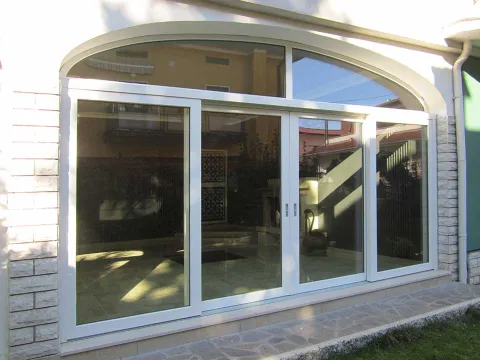 Portafinestra alzante-scorrevole in PVC con sopraluce a sesto lato esterno
