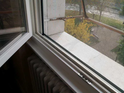Finestra in legno lamellare laccato bianco con zanzariera (particolare)