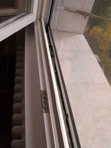 Finestra in legno lamellare laccato bianco con zanzariera (particolare)