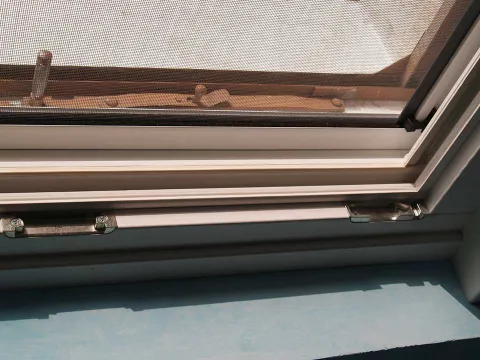 Finestra in legno lamellare laccato bianco con zanzariera (particolare)