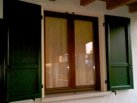 Finestra in legno lamellare, scuri in alluminio RAL a doghe verticali